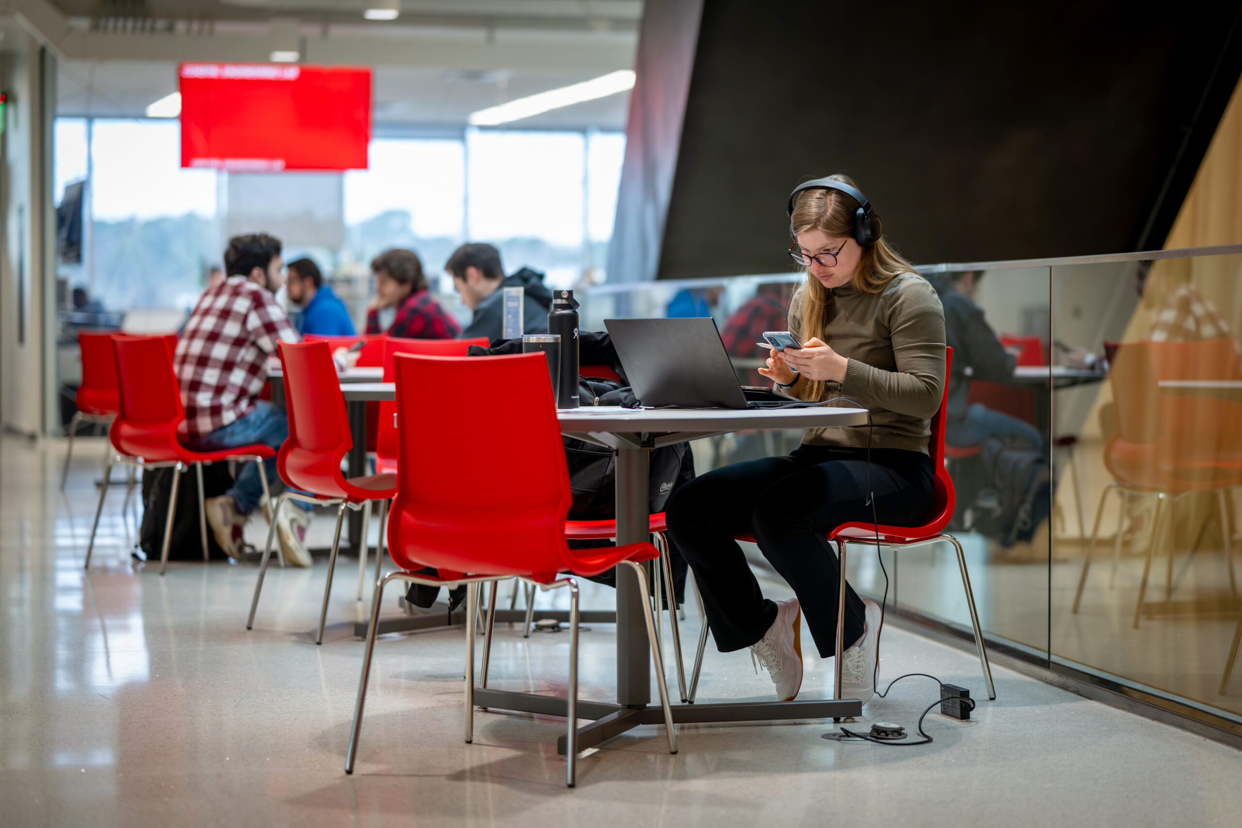 Engineering students warm up in the Fitts-Woolard Engineering building on a cold winter day, using the open spaces to study and attend class.